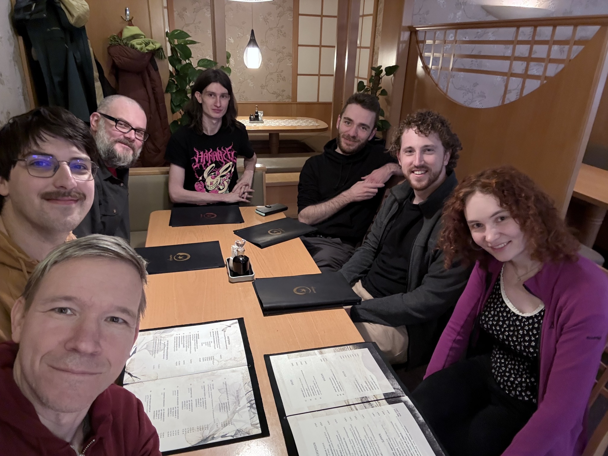 Group picture/selfie at a japanese restaurant. Seven people are smilling at the camera.